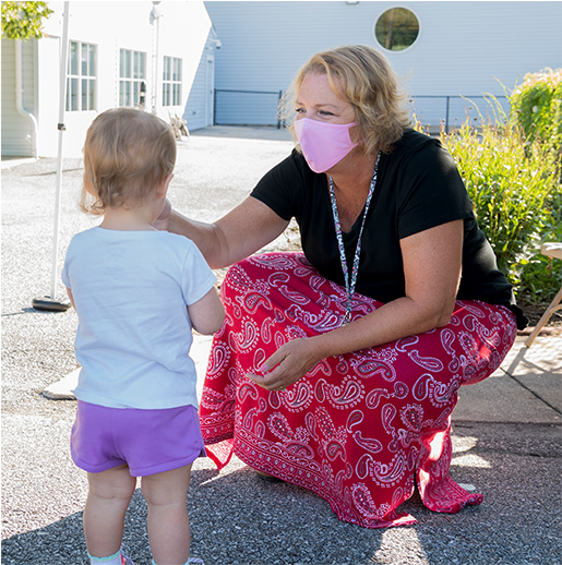 Teacher taking a toddler's temperature outside the Early Learning Center