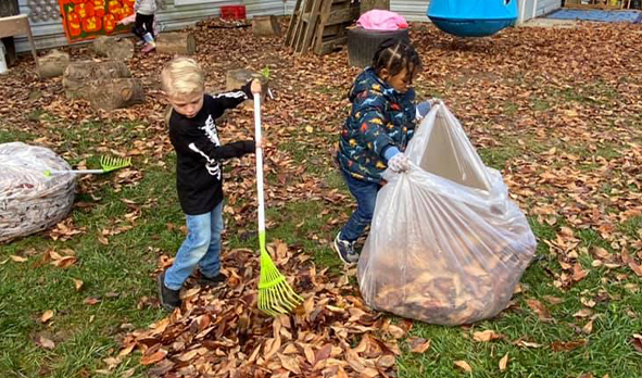 Two children raking leaves at the Early Learning Center